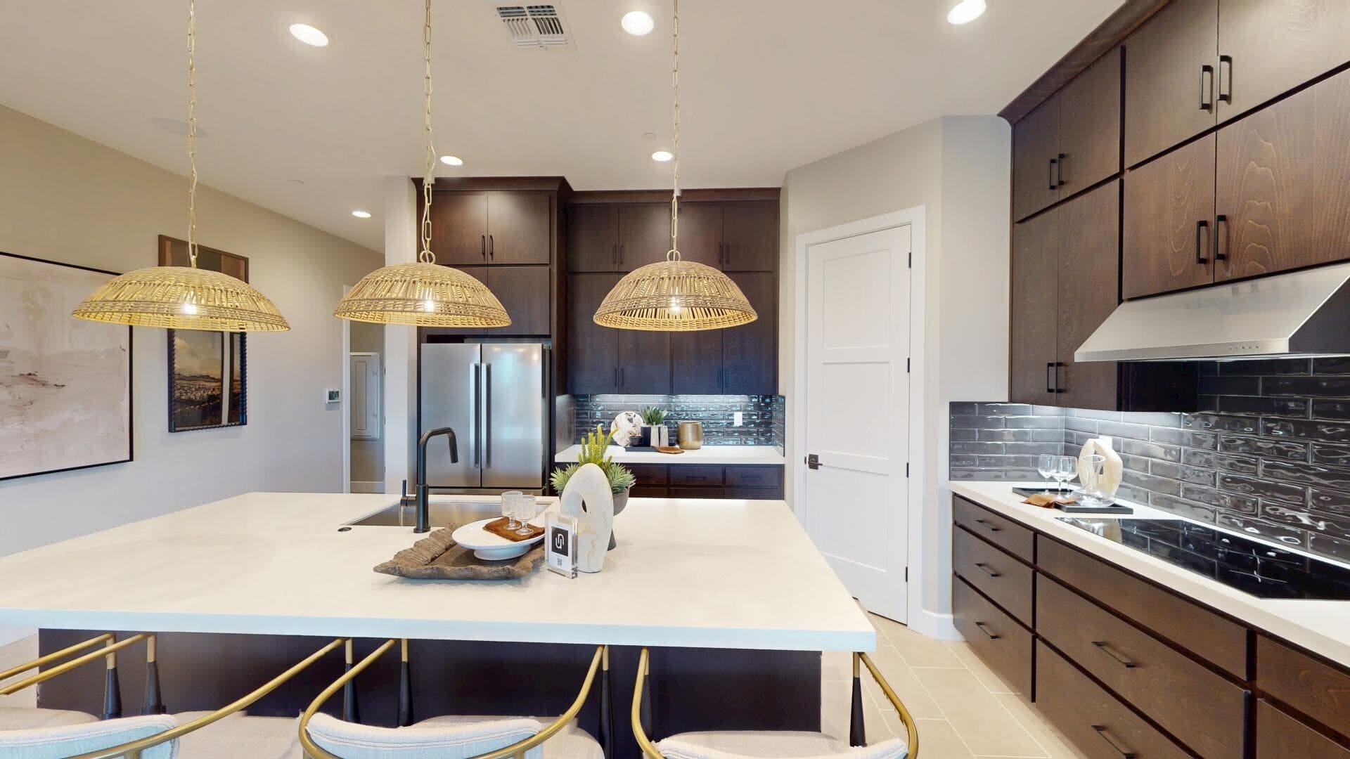 Espresso stained kitchen cabinets with white quartz island and woven rattan pendant lights