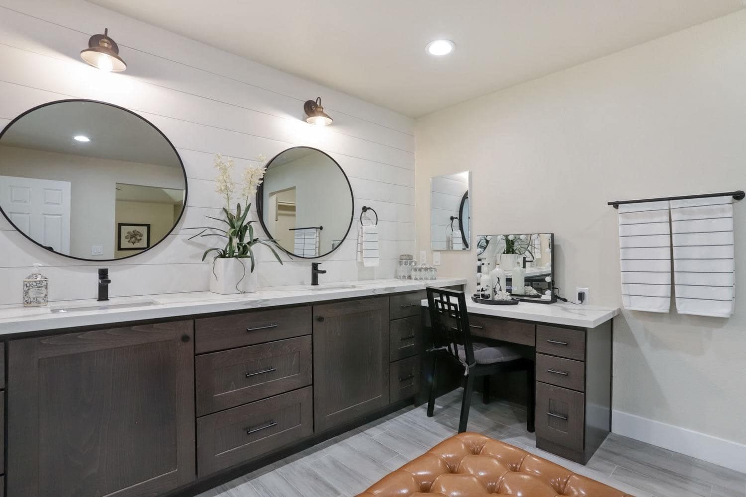 Custom dark wood bathroom vanity with built-in makeup desk