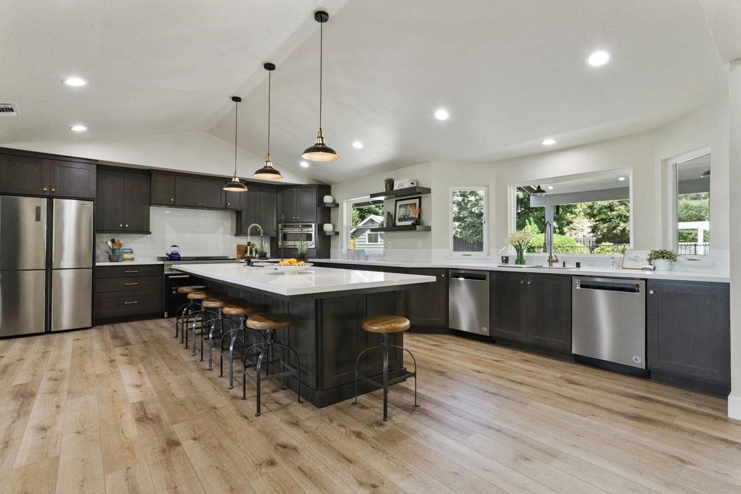 Roseville kitchen with espresso-stained custom shaker cabinets, long white quartz island and vaulted ceiling
