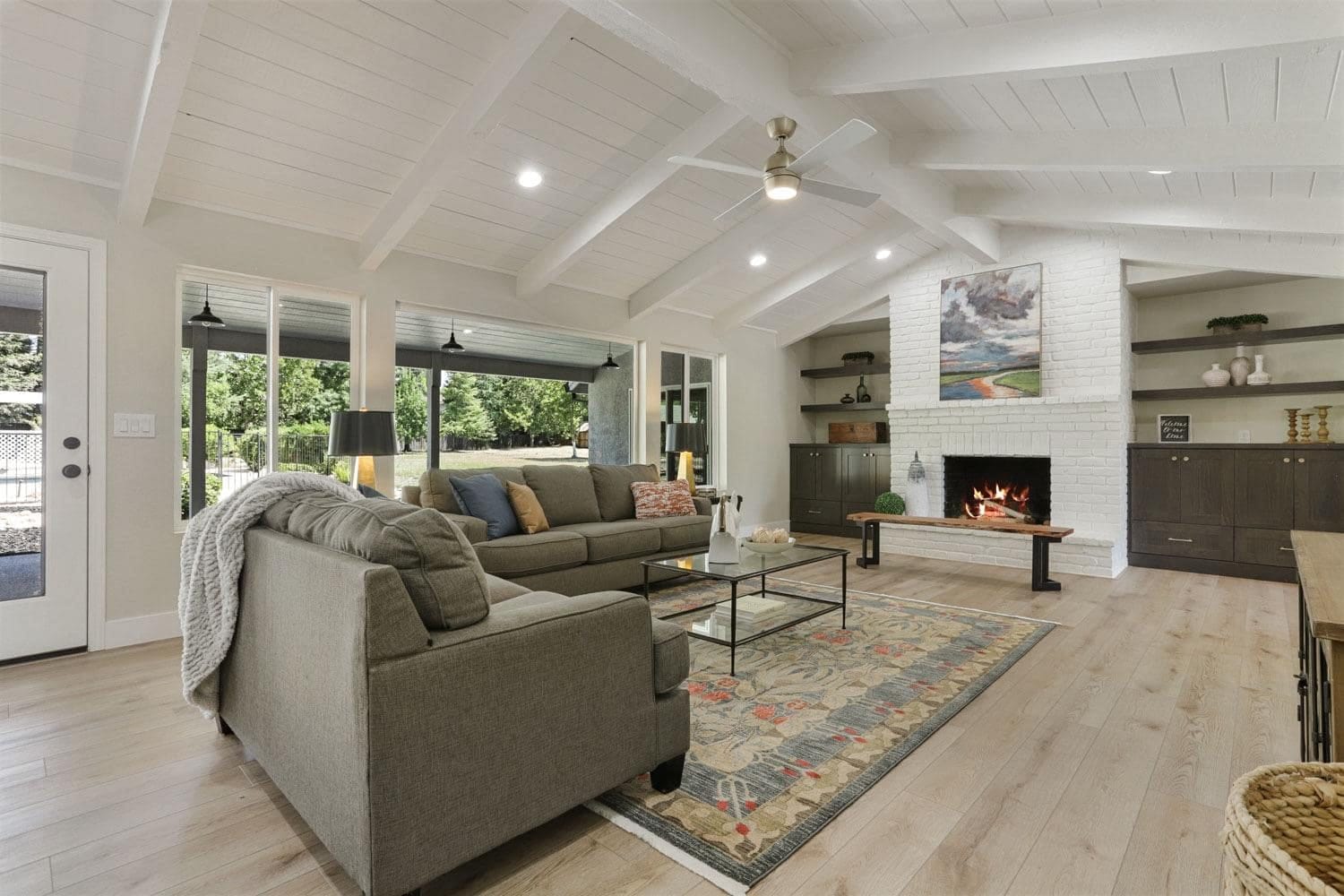 Custom built-in shelves and cabinets flanking a white brick fireplace