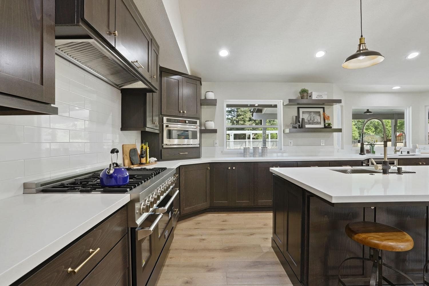 Custom range wall with espresso cabinets, brass pulls and white subway tile