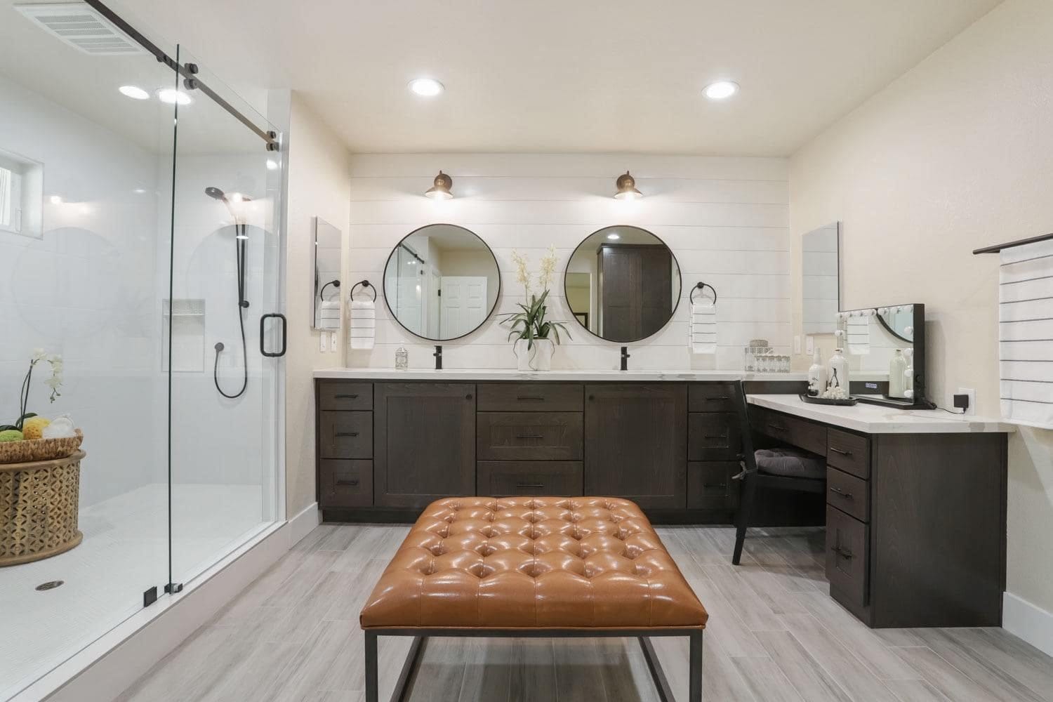 Primary bath with espresso vanity cabinets beside a glass walk-in shower
