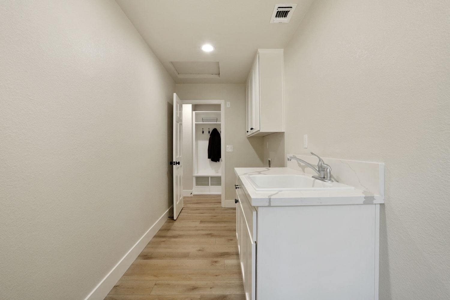 White laundry room cabinets with utility sink