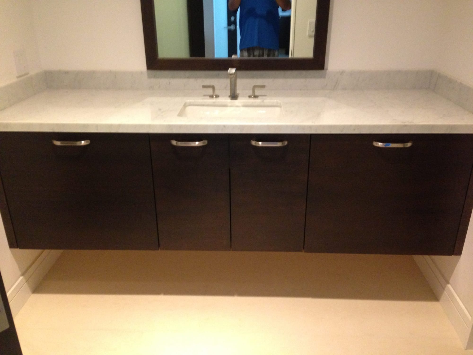Floating espresso bathroom vanity with Carrara marble countertop