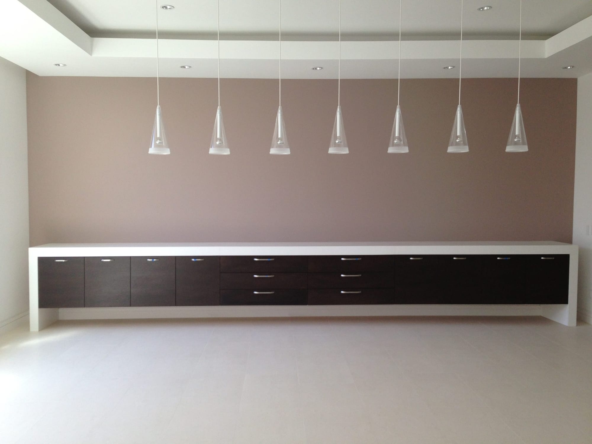Sacramento dining room with a long floating espresso slab-door sideboard, white quartz top and glass pendant lights