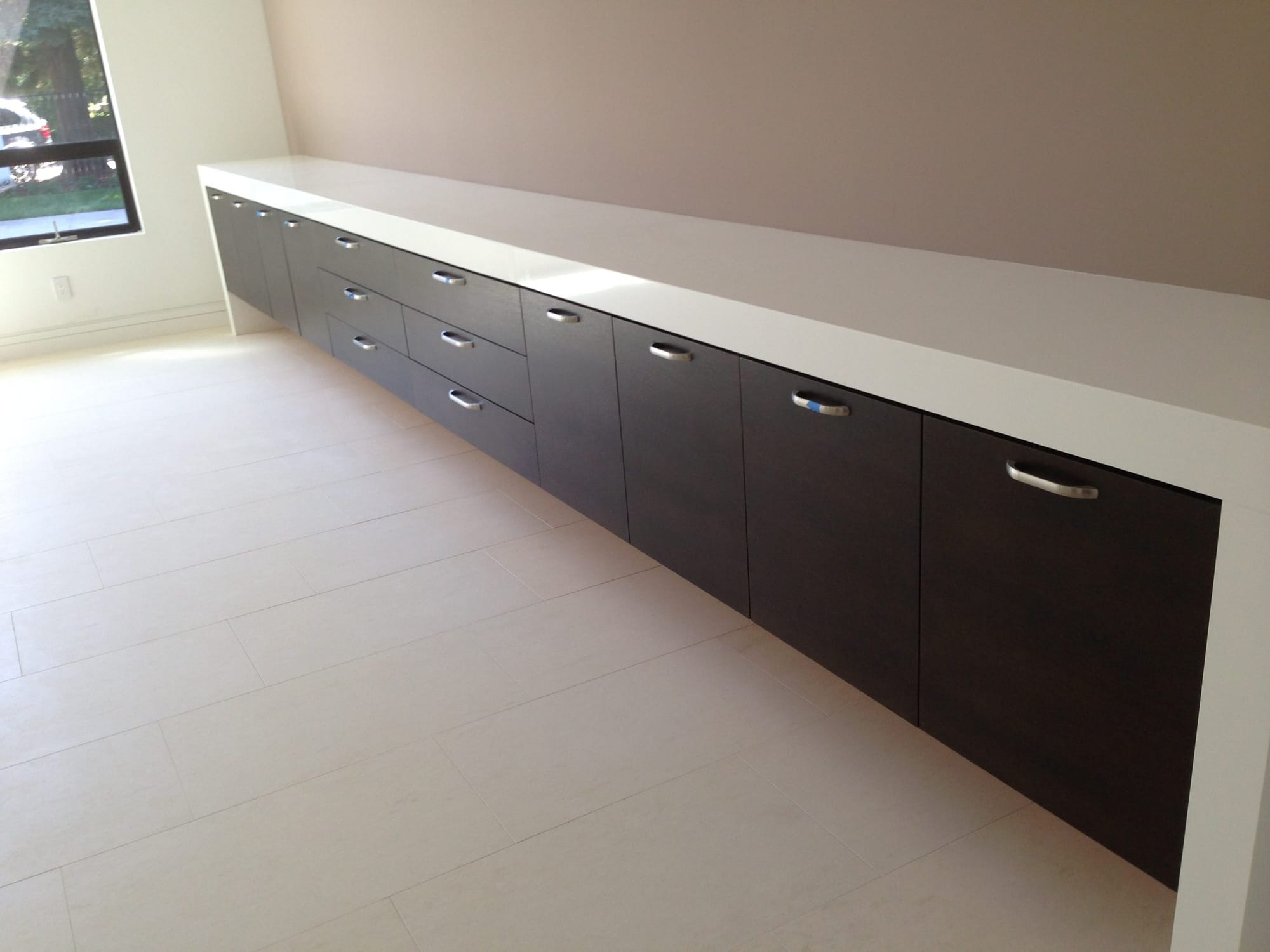 Long run of floating flat-slab espresso cabinets along a Sacramento wall