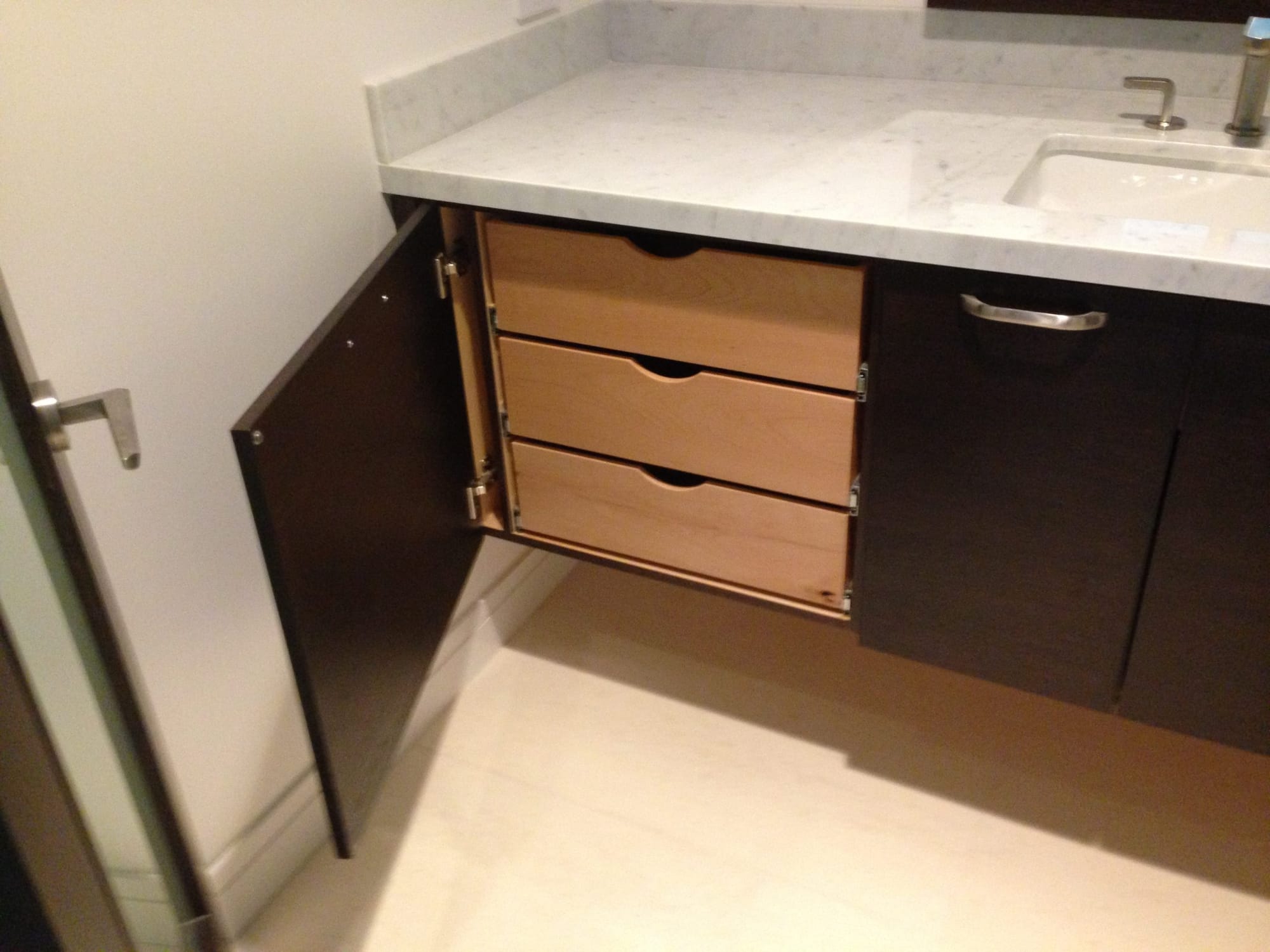 Bathroom vanity opened to show custom roll-out wood drawers