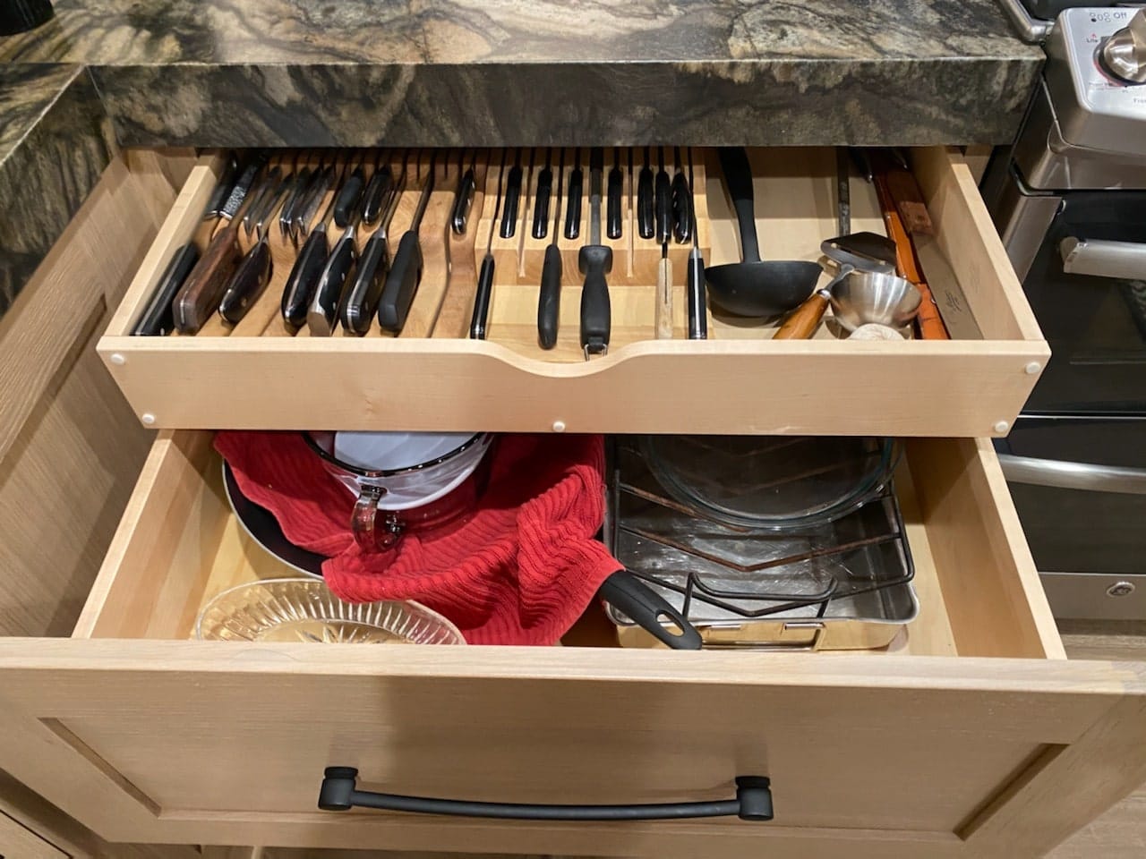 Custom knife block drawer insert in a white oak kitchen cabinet