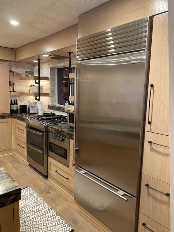 White oak tall cabinets framing a built-in stainless refrigerator