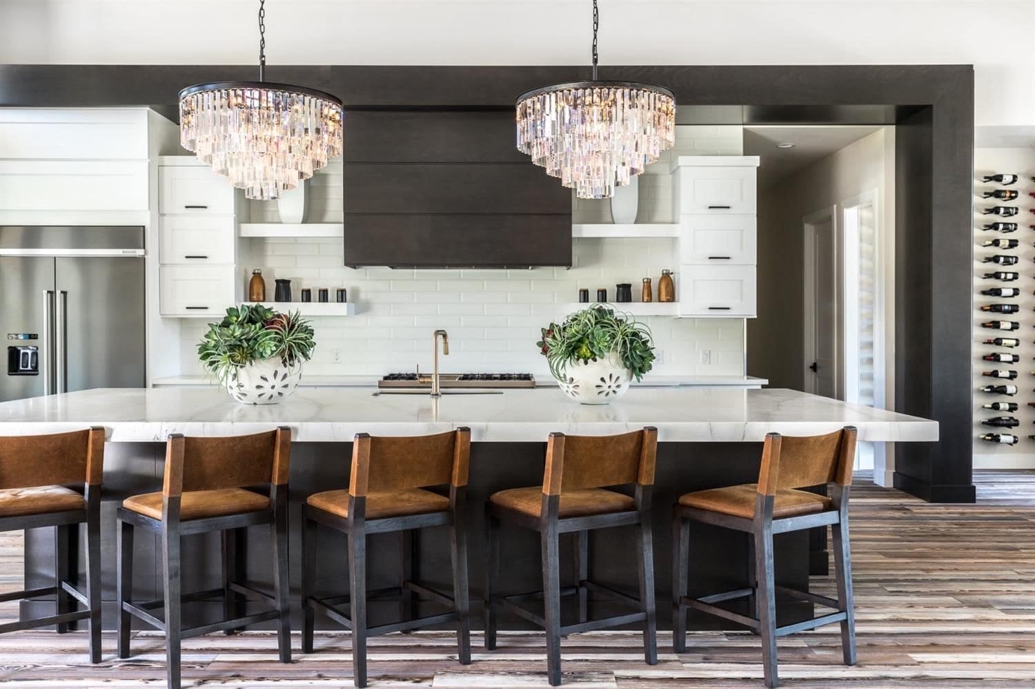 Woodland, CA modern farmhouse kitchen with white cabinets, espresso island and range hood, and crystal chandeliers